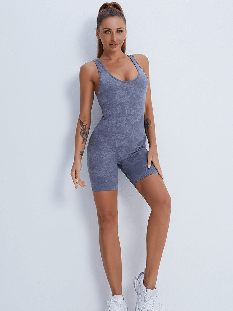 Woman wearing blue sleeveless seamless jumpsuit for yoga, showcasing sporty, comfortable fit with quick-drying fabric.